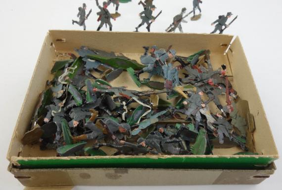 about 50 tinnie toy soldiers in original box
